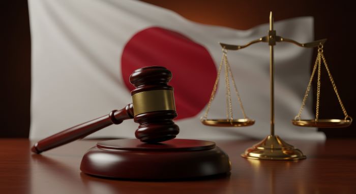 日本国旗を背景にした裁判用ハンマーと天秤
